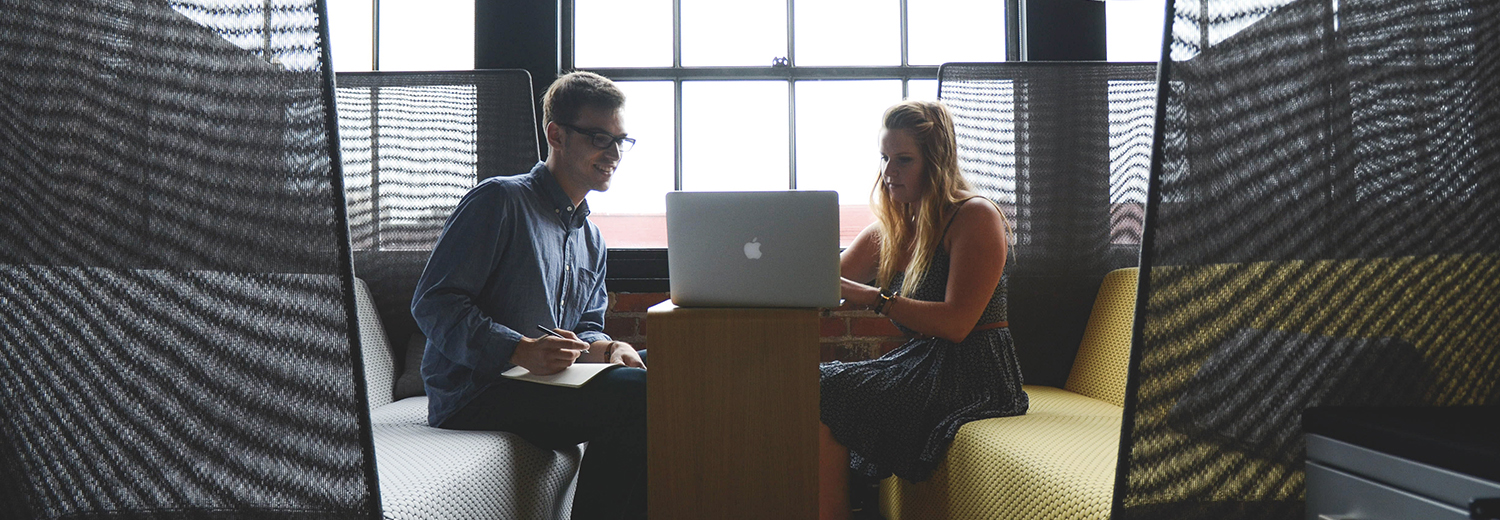 Two people work across from each other, one leading.